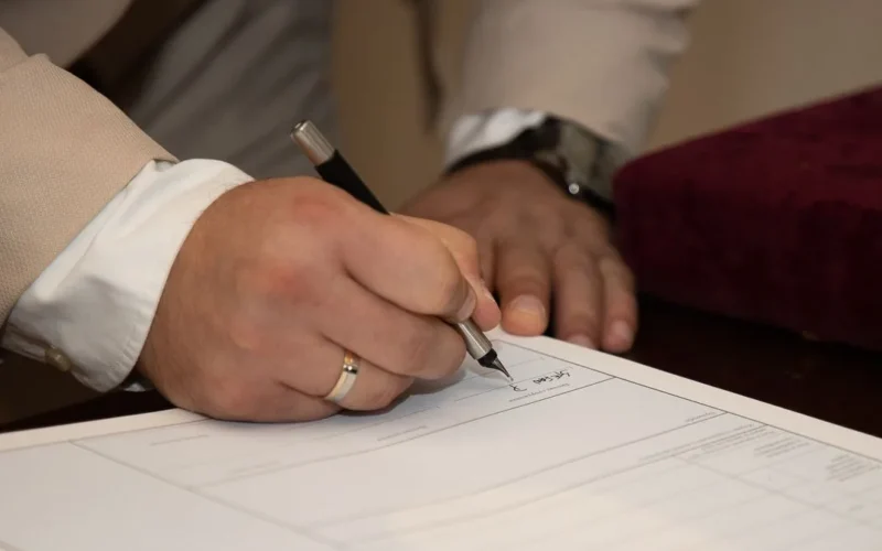 Firma de documento de compraventa de un inmueble sobre un escritorio